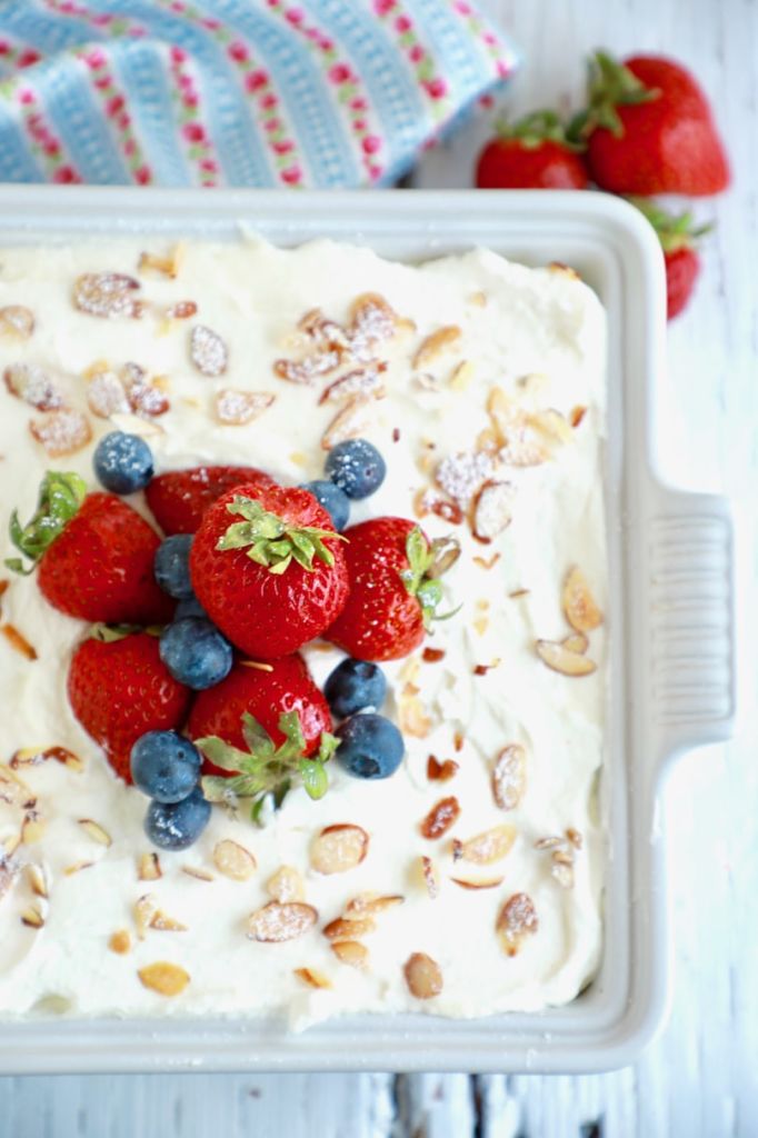 Berry tiramisu is topped with slivered almonds, fresh strawberries, and blueberries.