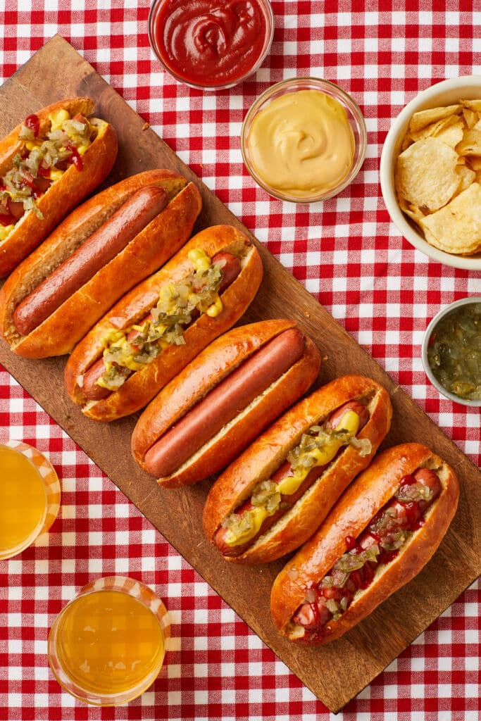 Easy Homemade Hot Dog Buns are served with sausages, relish, mustard, and ketchup.