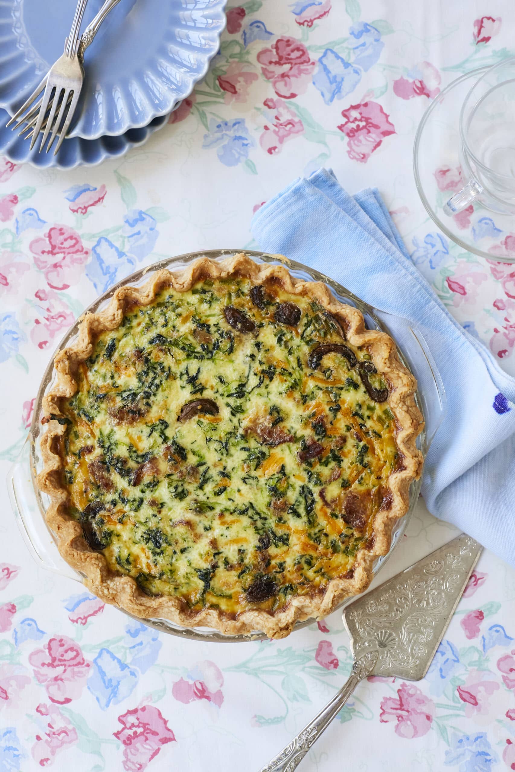 A homemade Quiche with golden, flaky Homemade Buttermilk Pie Crust. it's loaded with eggs, sausage, mushrooms, spinach, and cheese.
