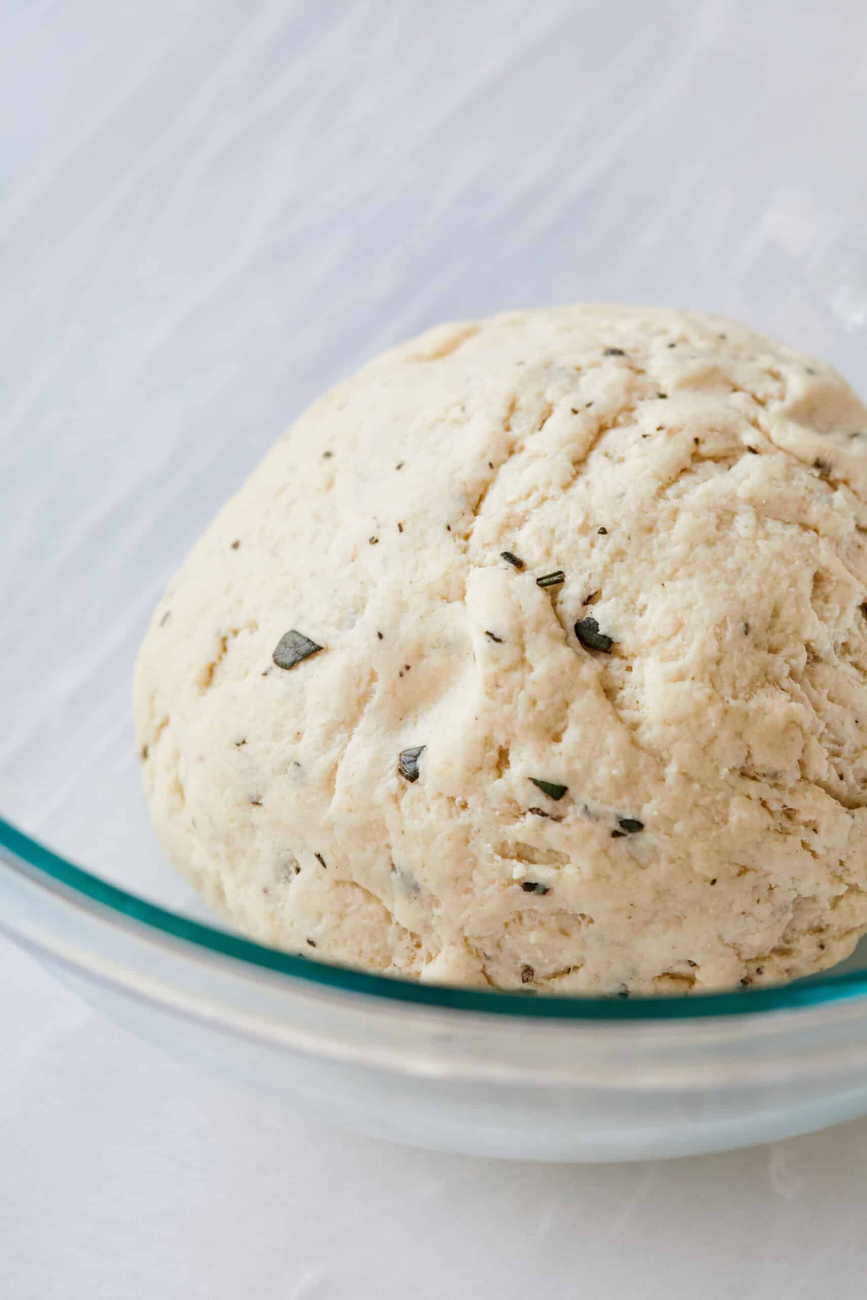 Step-by-step instructions on how to Make Carta di Musica: combine dry ingredients and wet ingredients then knead until a smooth dough is formed.