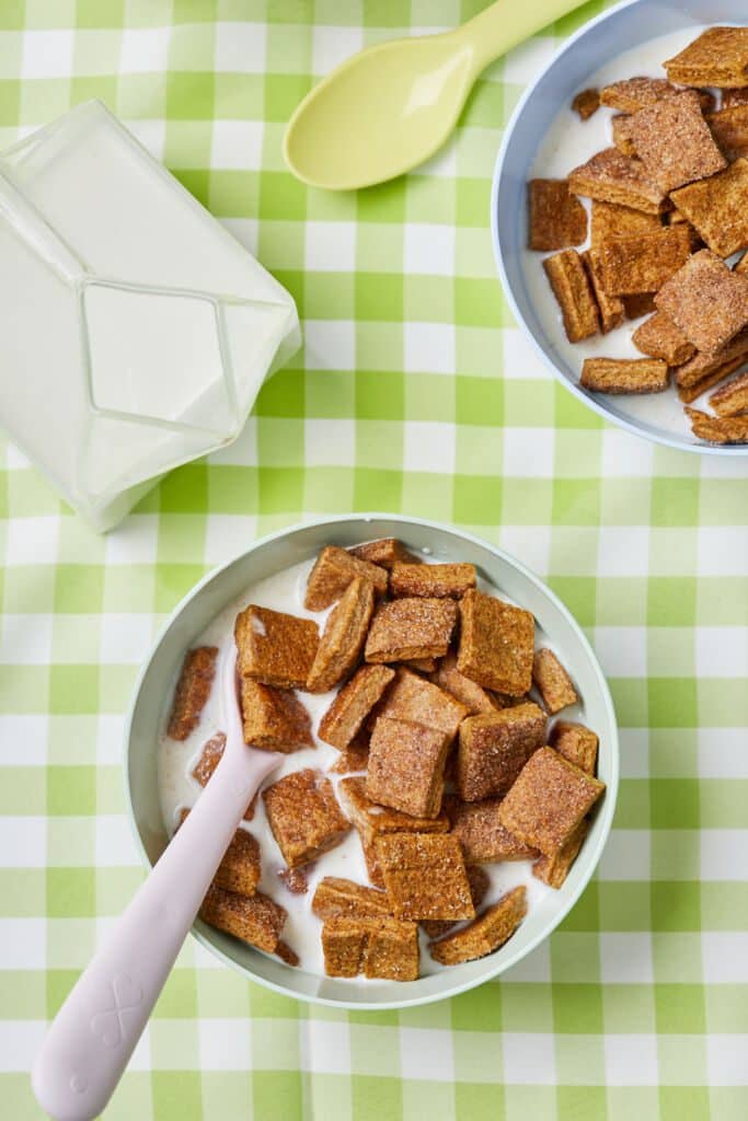 Homemade Cinnamon Toast Crunch is served with milk in two bowls.
