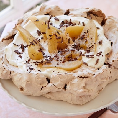 Crispy Baked Chocolate Meringue is topped with mascarpone whipped cream, then poached pears and chocolate shaves.