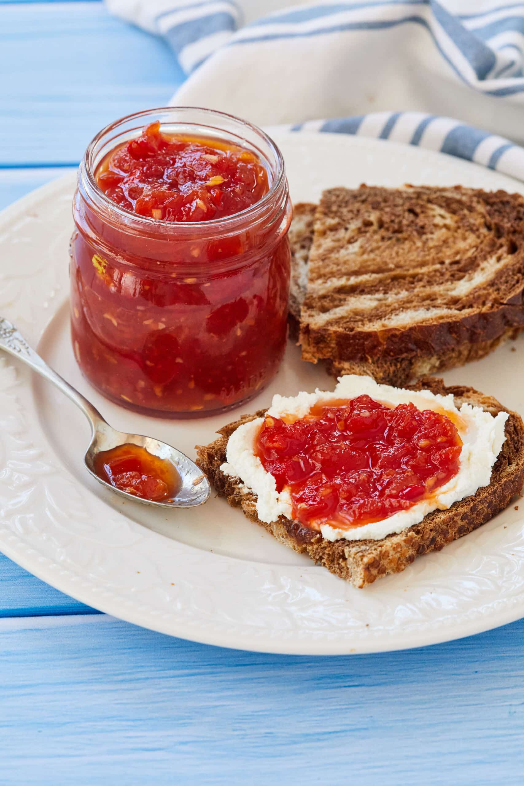 Tomato Chilli Chutney is in a jar and served with toast.