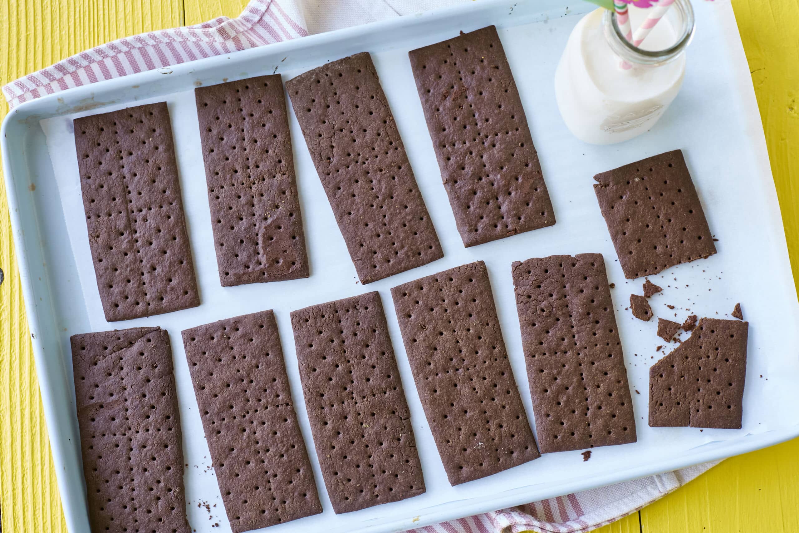 An overhead-view shot of a tray of perfectly baked Homemade Chocolate Graham Crackers, served with milk.