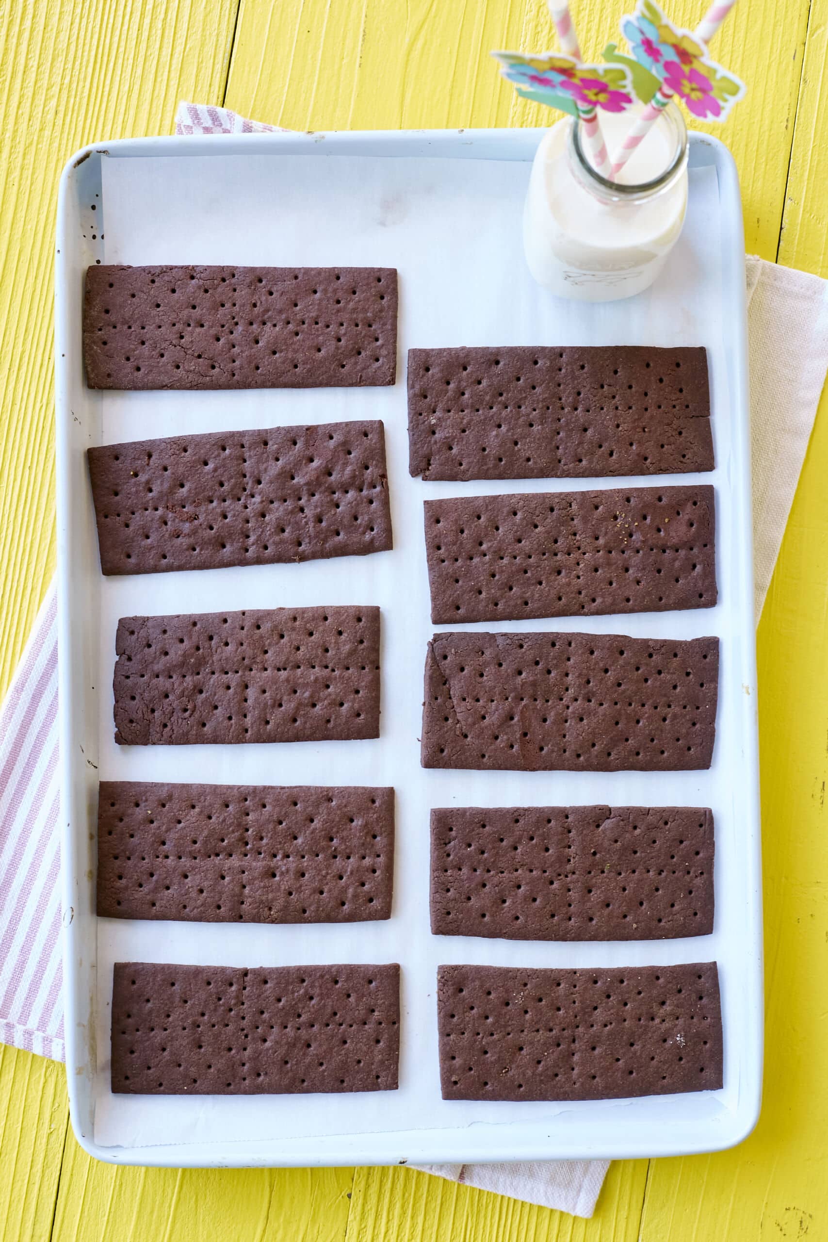 An overhead shot of a tray of perfectly baked Homemade Chocolate Graham Crackers, served with milk.