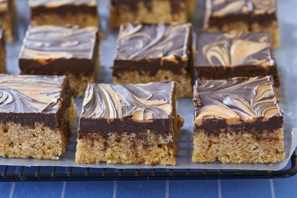 A close-up shot at the Easy Scotcheroos shows the crispy rice cereal bottom and the chocolate top layer with swirls of peanut butter.