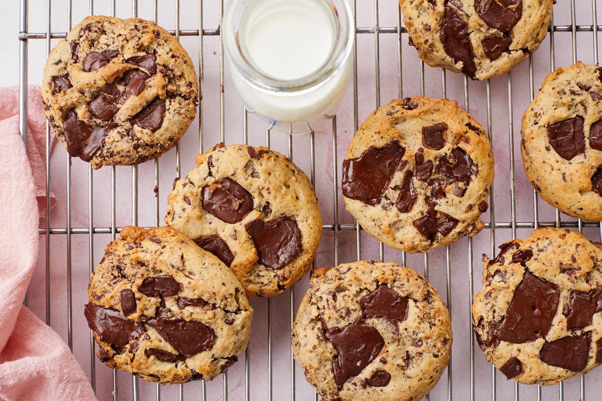 A top down view of Cream Cheese Chocolate Chip Cookies served on a cooling rack with milk.