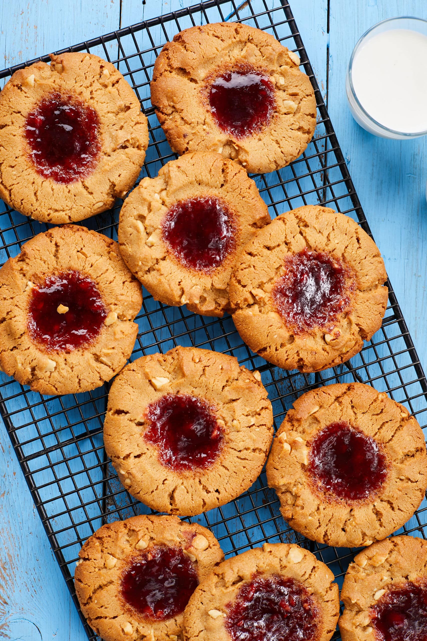 Peanut Butter and Jelly Thumbprint cookies are baked until golden brown with jelly in the centers and crackled tops.