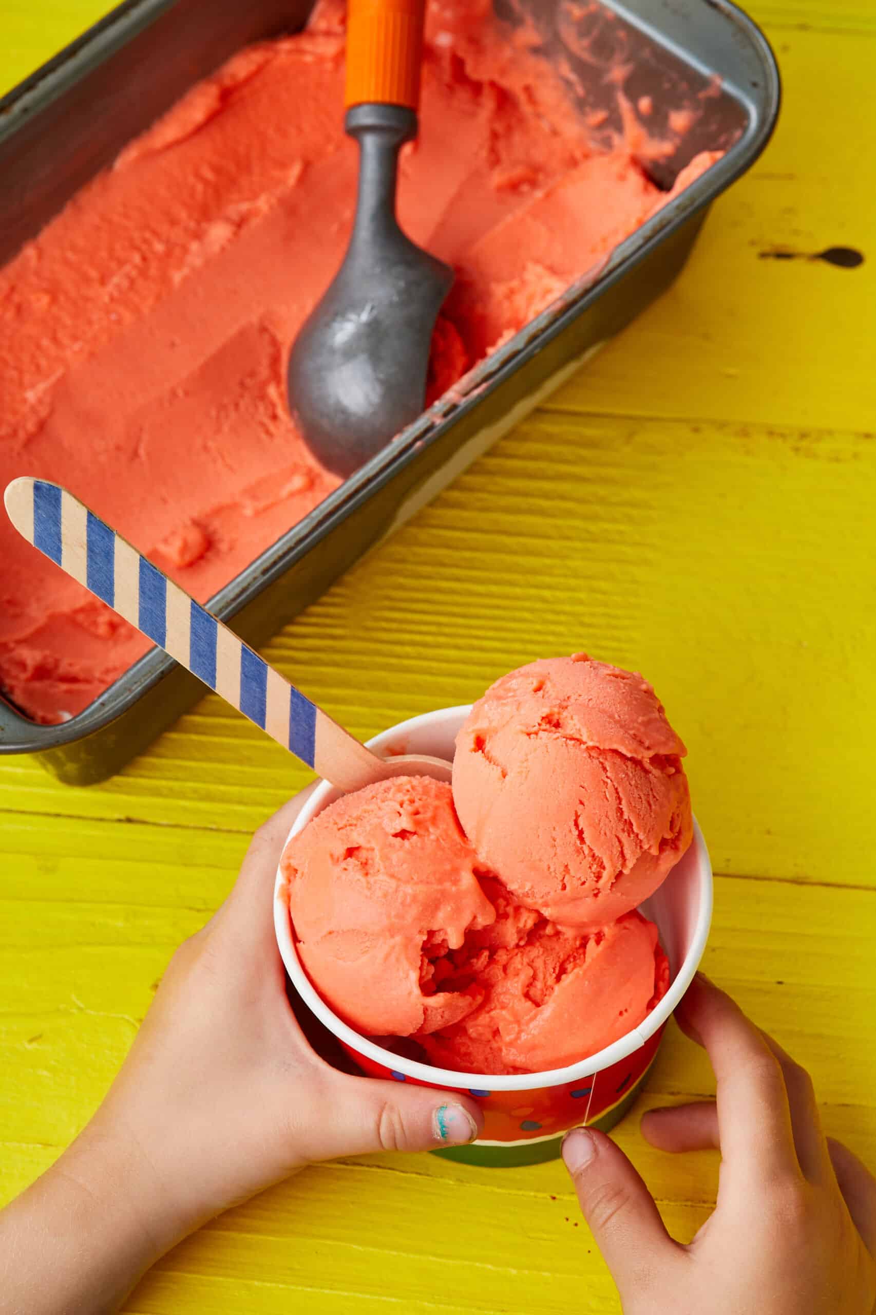 Scoops of Sicilian Eggless Watermelon Gelato are served in a paper cup.