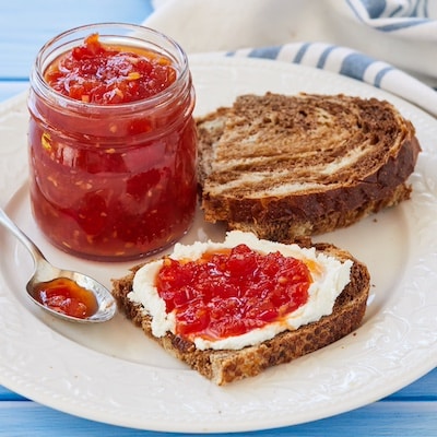Tomato Chilli Chutney is in a jar and served with toast.