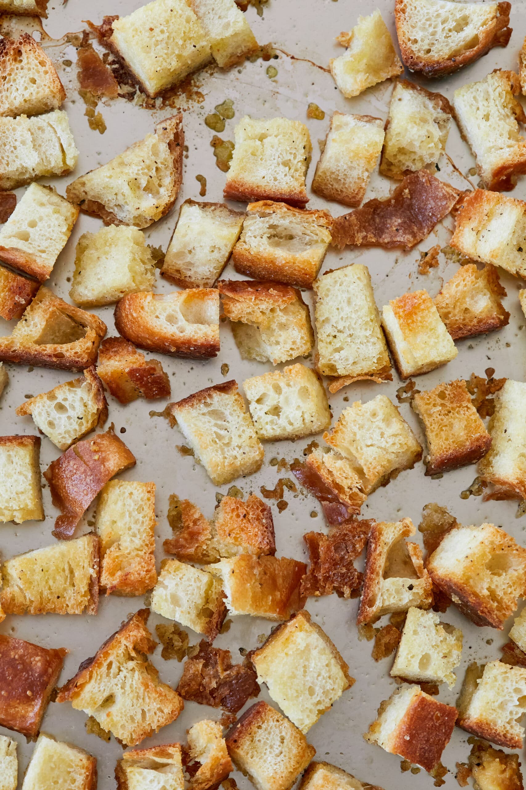 Homemade croutons on the baking tray are golden and crispy, tossed with seasoning.