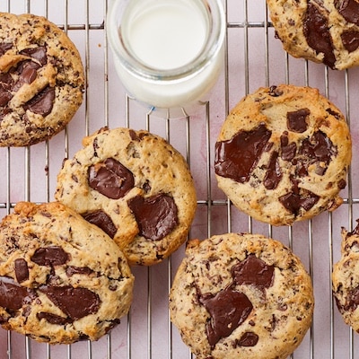 A top down view of Cream Cheese Chocolate Chip Cookies served on a cooling rack with milk.